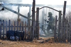 Firefighter moves hose at property that incurred heavy damage from fire Feb. 7 in the 800 block of Eggleston Street near Waverly in unincorporated Larimer County.  Wellington fire and several other agencies responded.