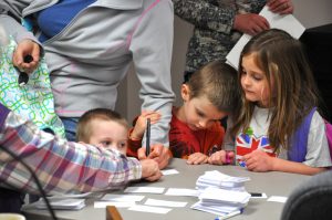 Town election on April 1 in Wellington. Ben, George and Rebekah Johnson watch as mom signs in to vote.  Photo by Doug Conarroe