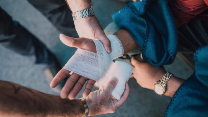 Person Applying Bandage on Another Person's Hand