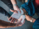 Person Applying Bandage on Another Person's Hand