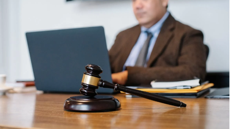 Crop Asian judge working on laptop in office https://www.pexels.com/photo/crop-asian-judge-working-on-laptop-in-office-5668772/